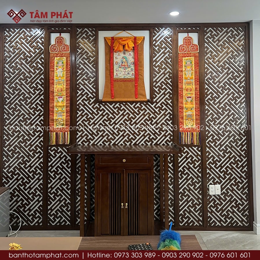 Trung tâm là tranh Thangka Phật Dược Sư treo trang trọng giữa hậu CNC hoa văn chữ Vạn, kèm hai cuộn phù hộ pháp hai bên – chuẩn phong cách Tây Tạng.